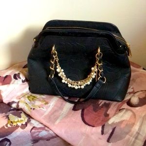 Charming Charlie purse with chain and floral detail.